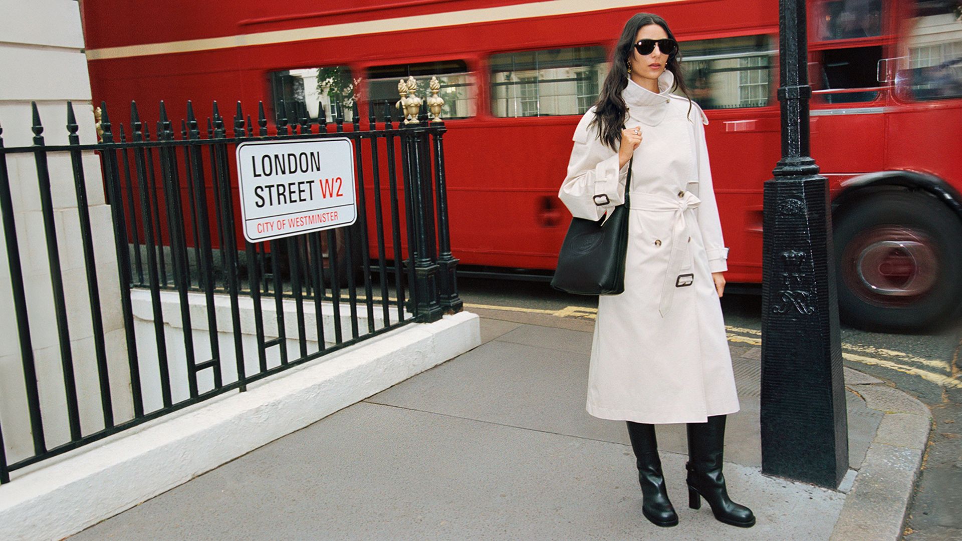 model in London street wearing off-whnite Burberry trench and black boots 