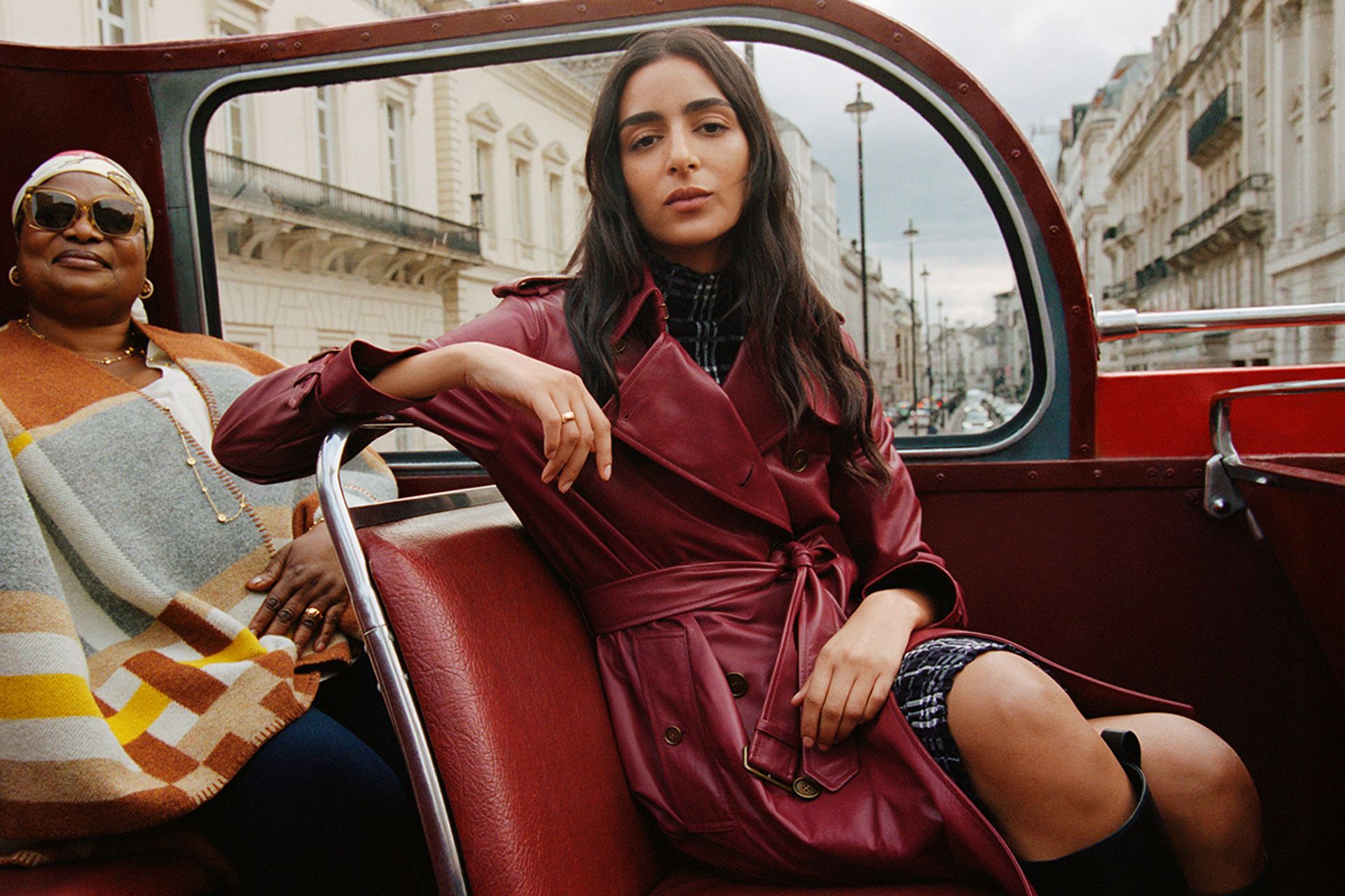 model on top deck of open top london bus wearing red leather coat for burberry campaign 