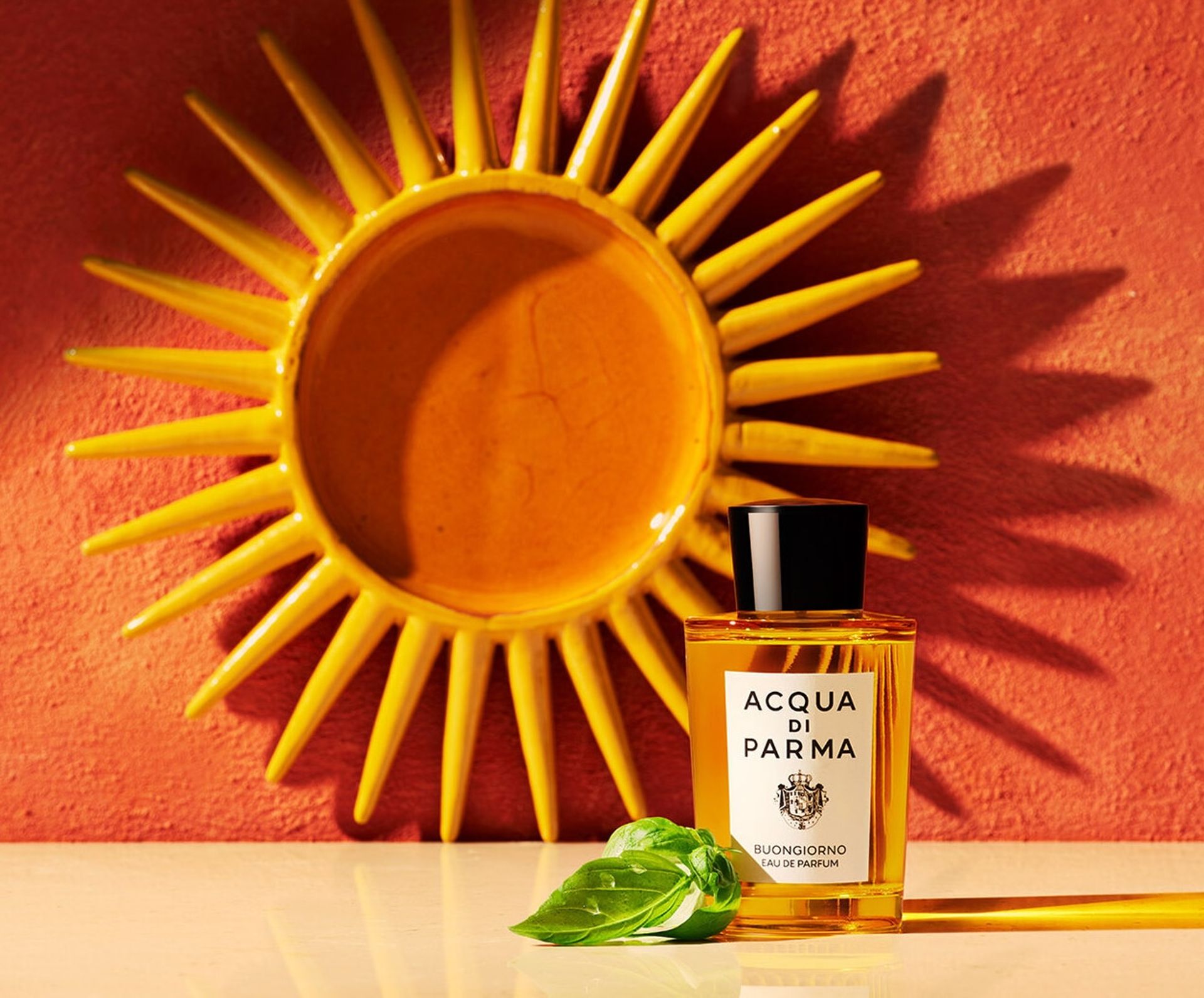 BUONGIORNO fragrance bottle in front of sun ornament
