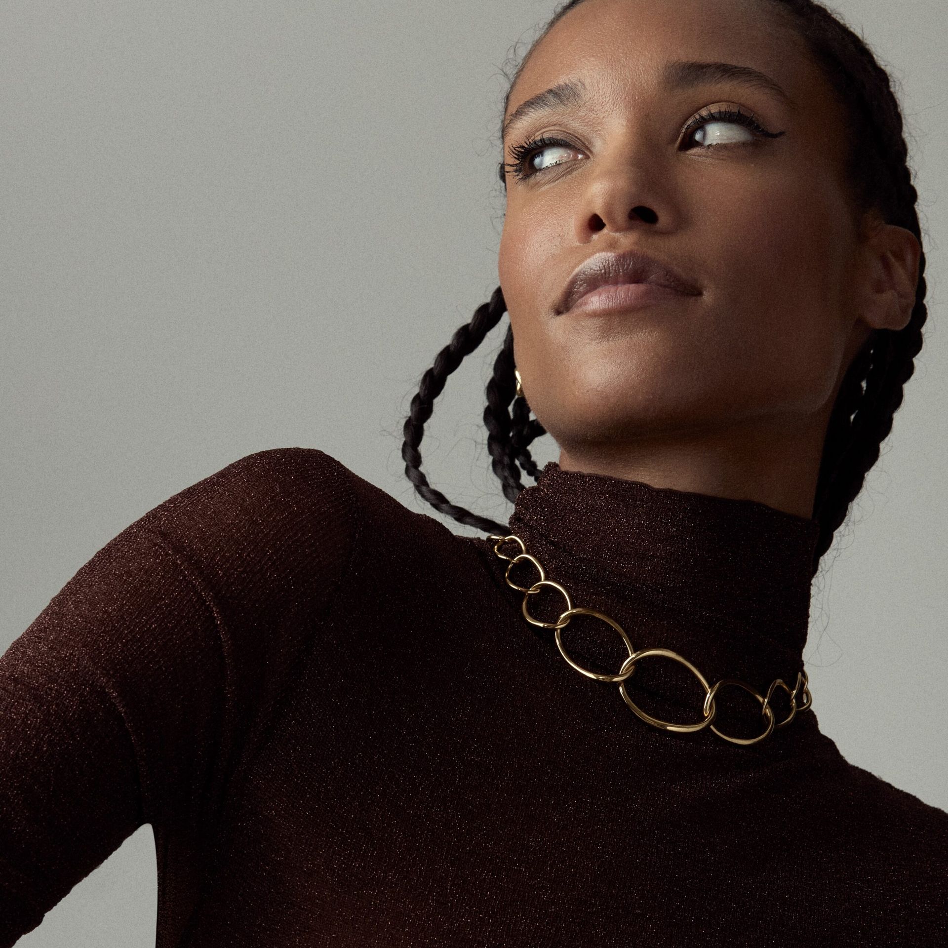 model wearing chain necklace over black poloneck