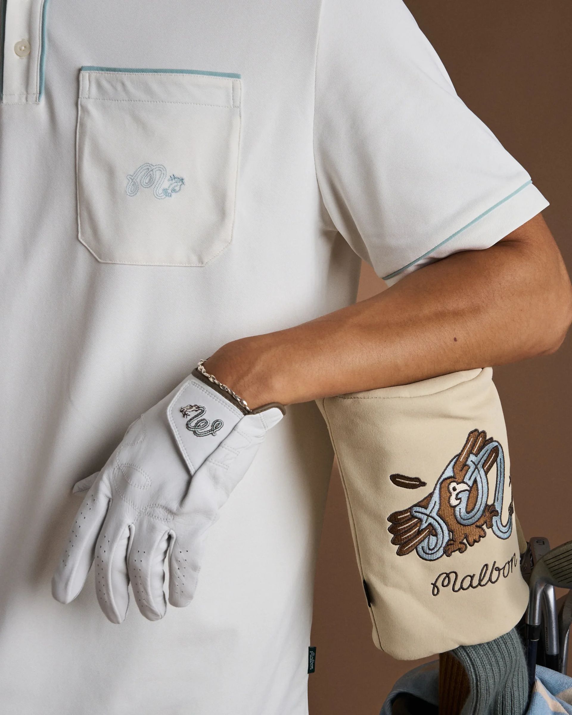 close up of hand wearing golf glove on clubs