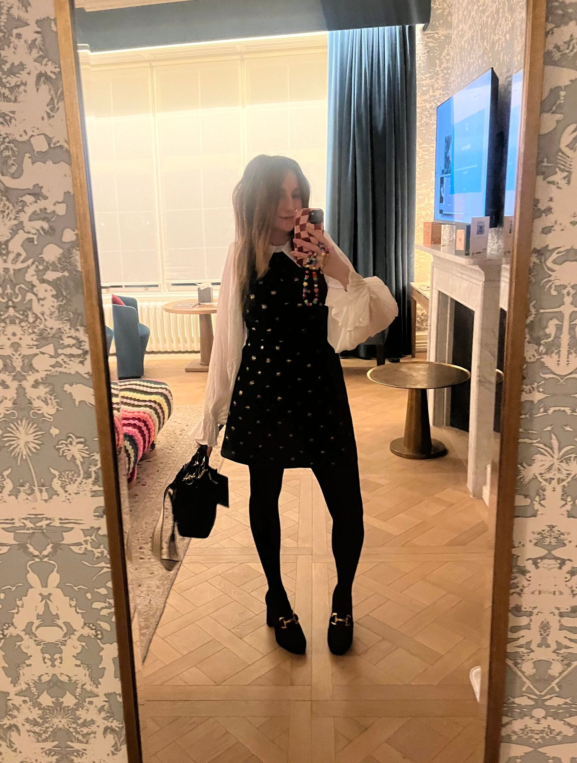 astrid taking a selfie in the mirror wearing black and white mini dress