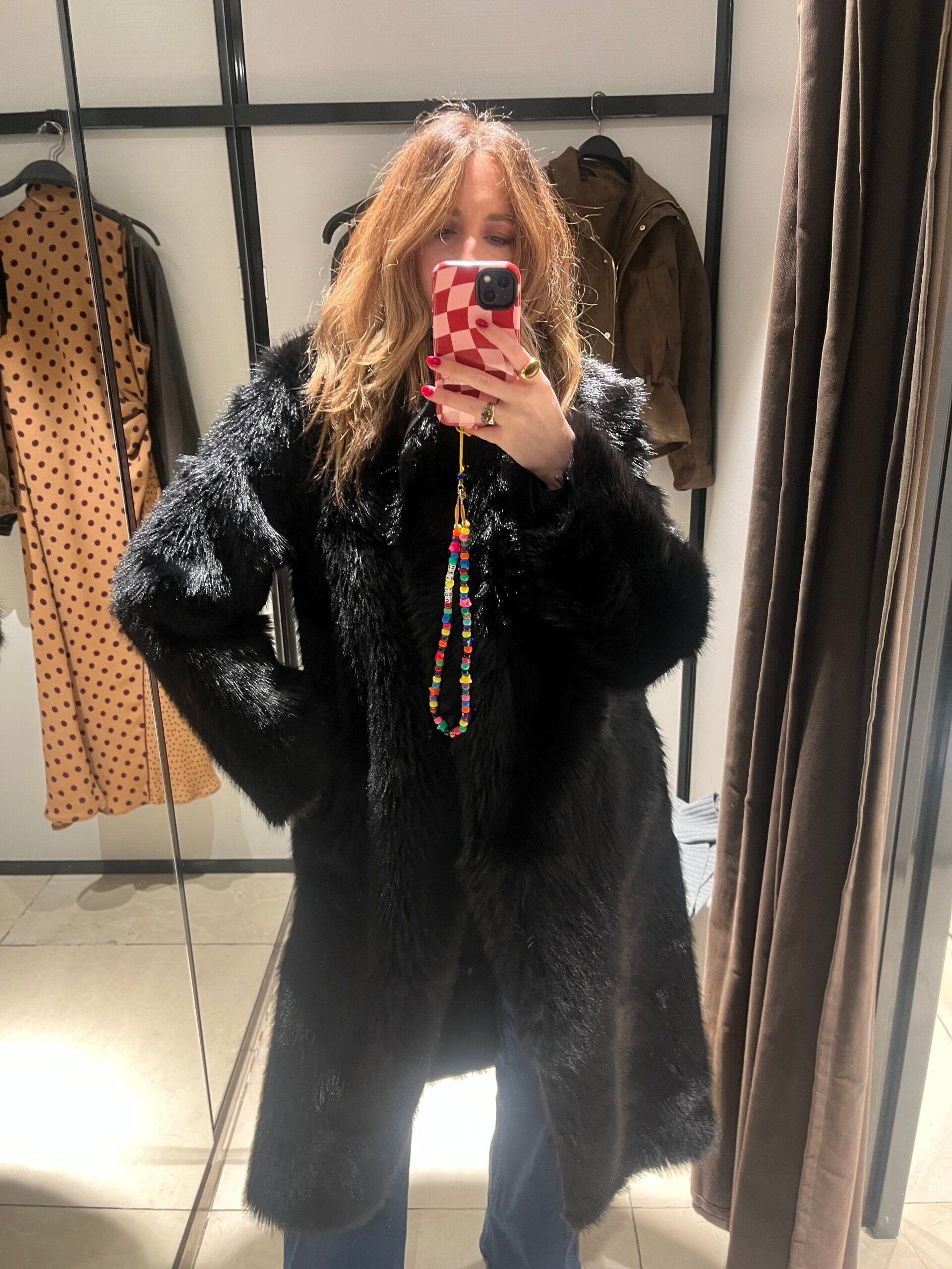 astrid in zara changing room wearing faux fur black coat 