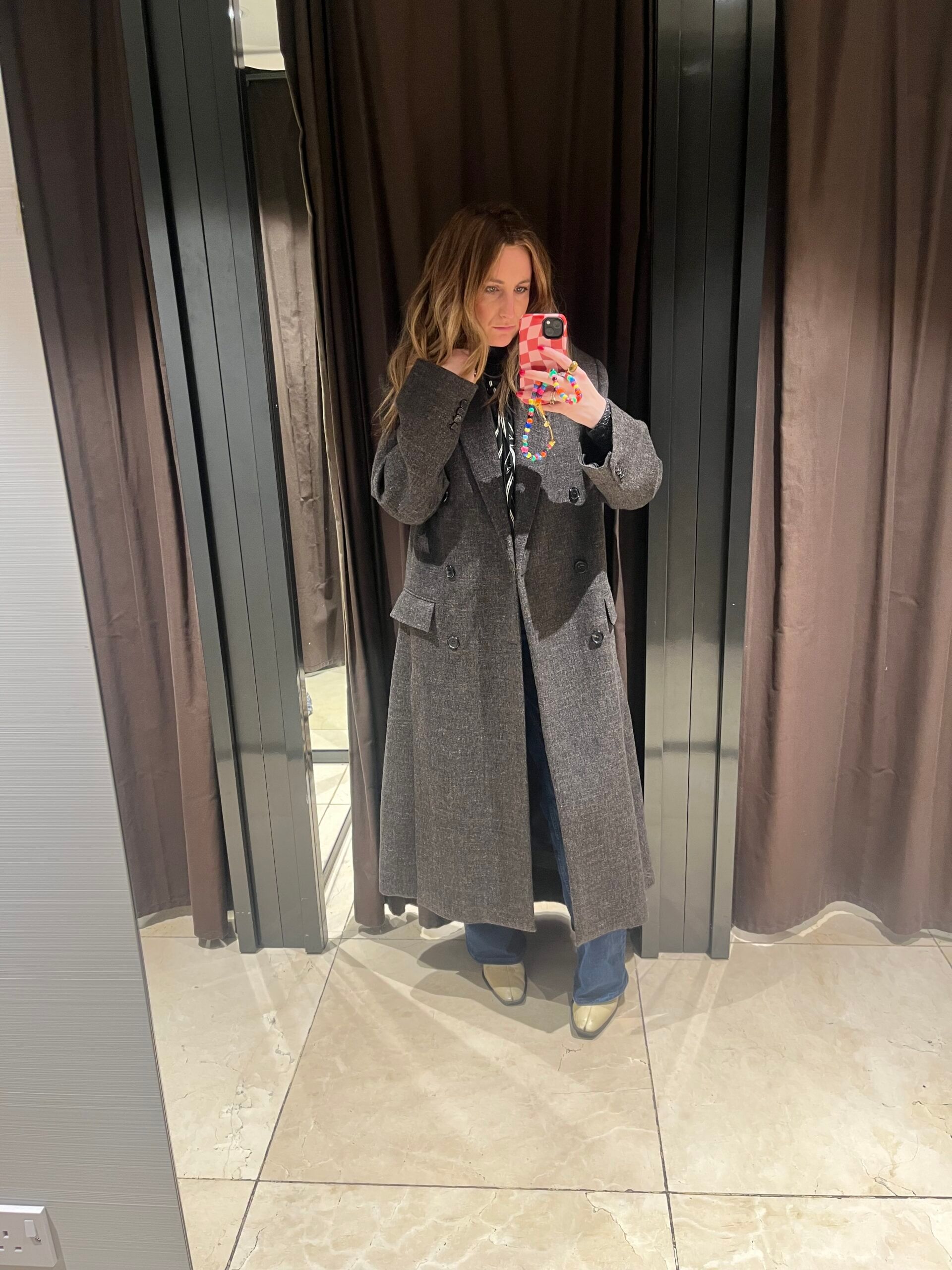 astrid in zara changing room wearing grey coat 