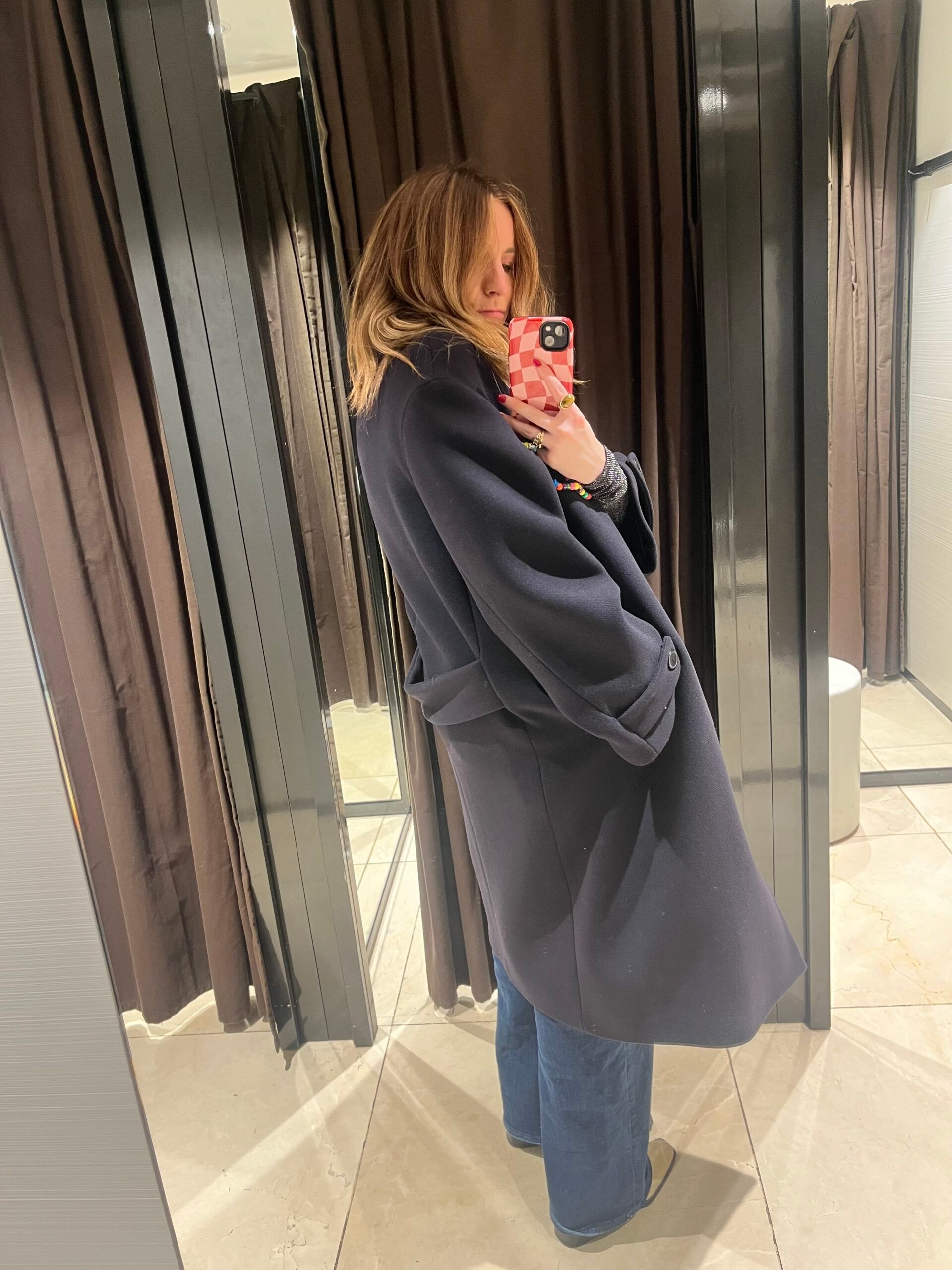 astrid in zara changing room wearing navy coat 