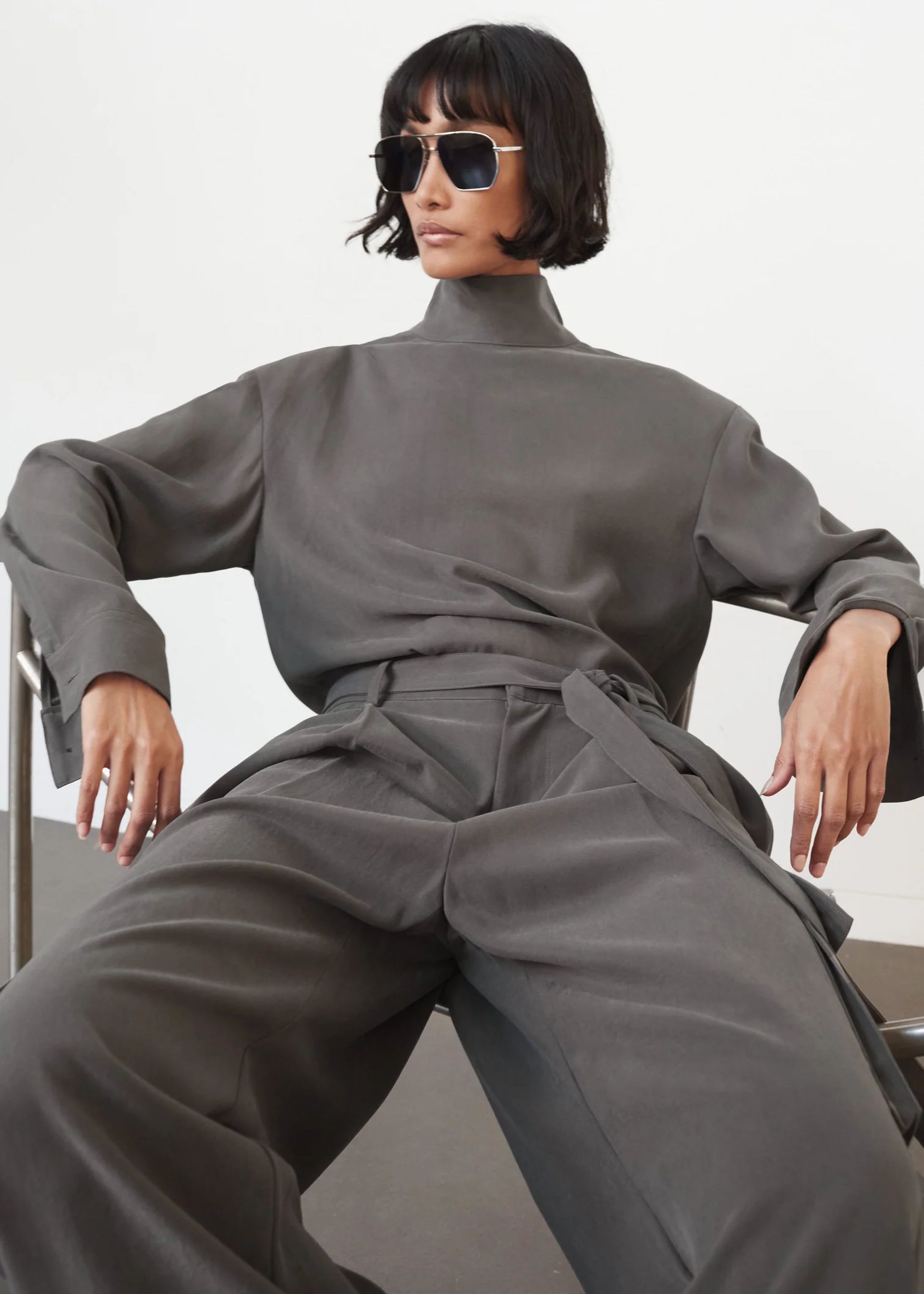 model sitting wearing Nyro Blouse In Charcoal