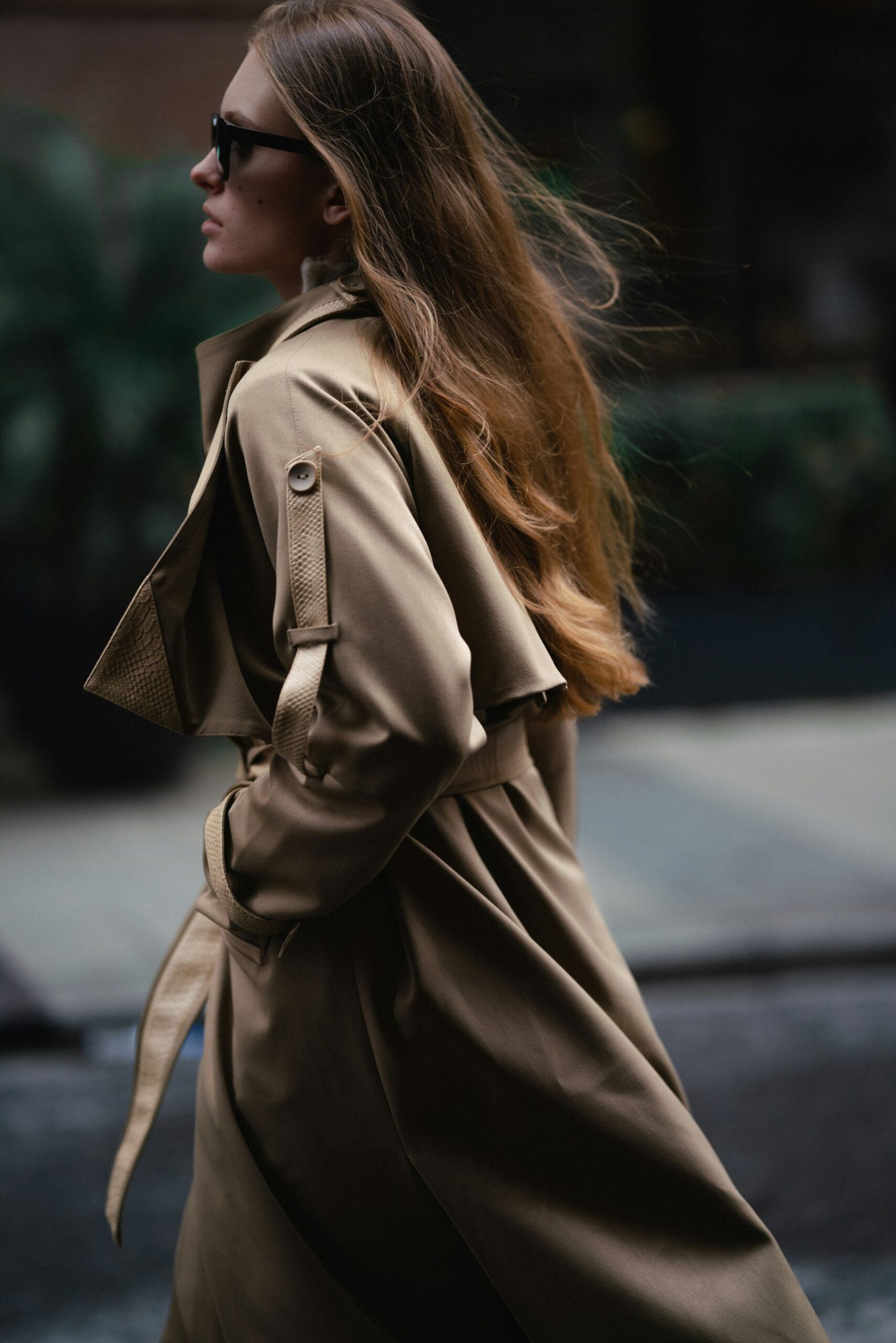 women wearing trench coat walking in street