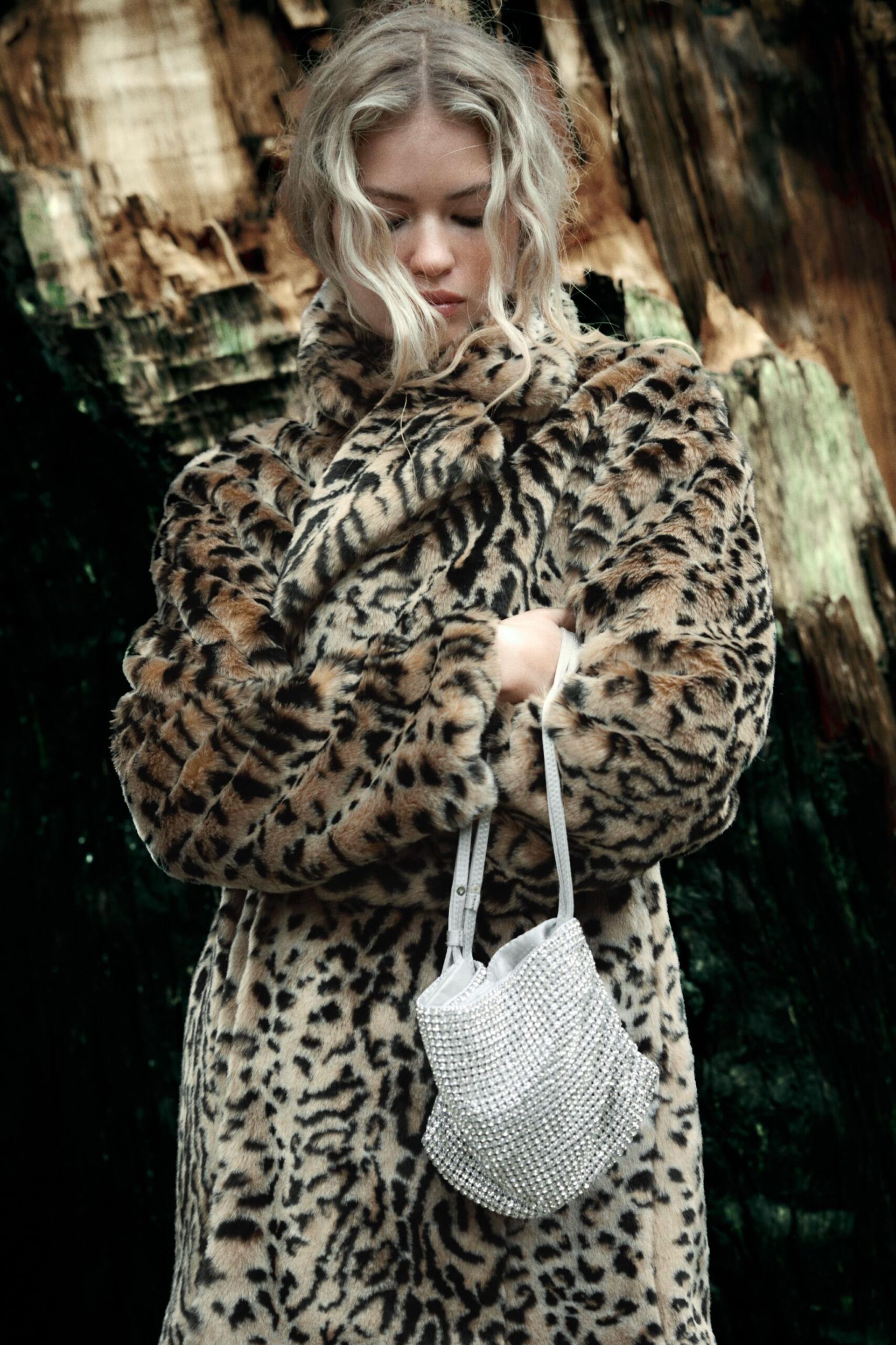 model wearing leopard print coat and holding silver party bag