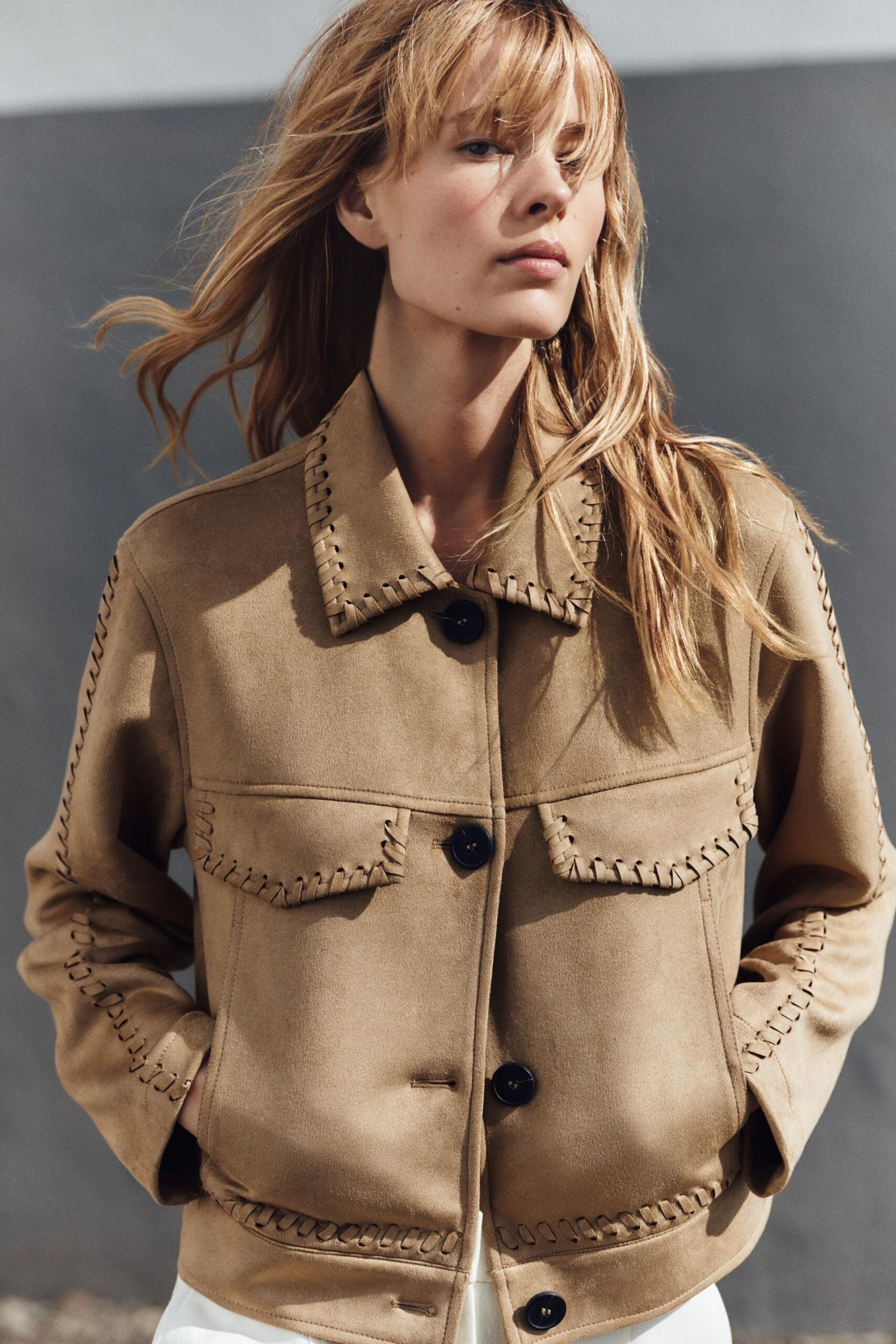 model wears suede jacket with stitching