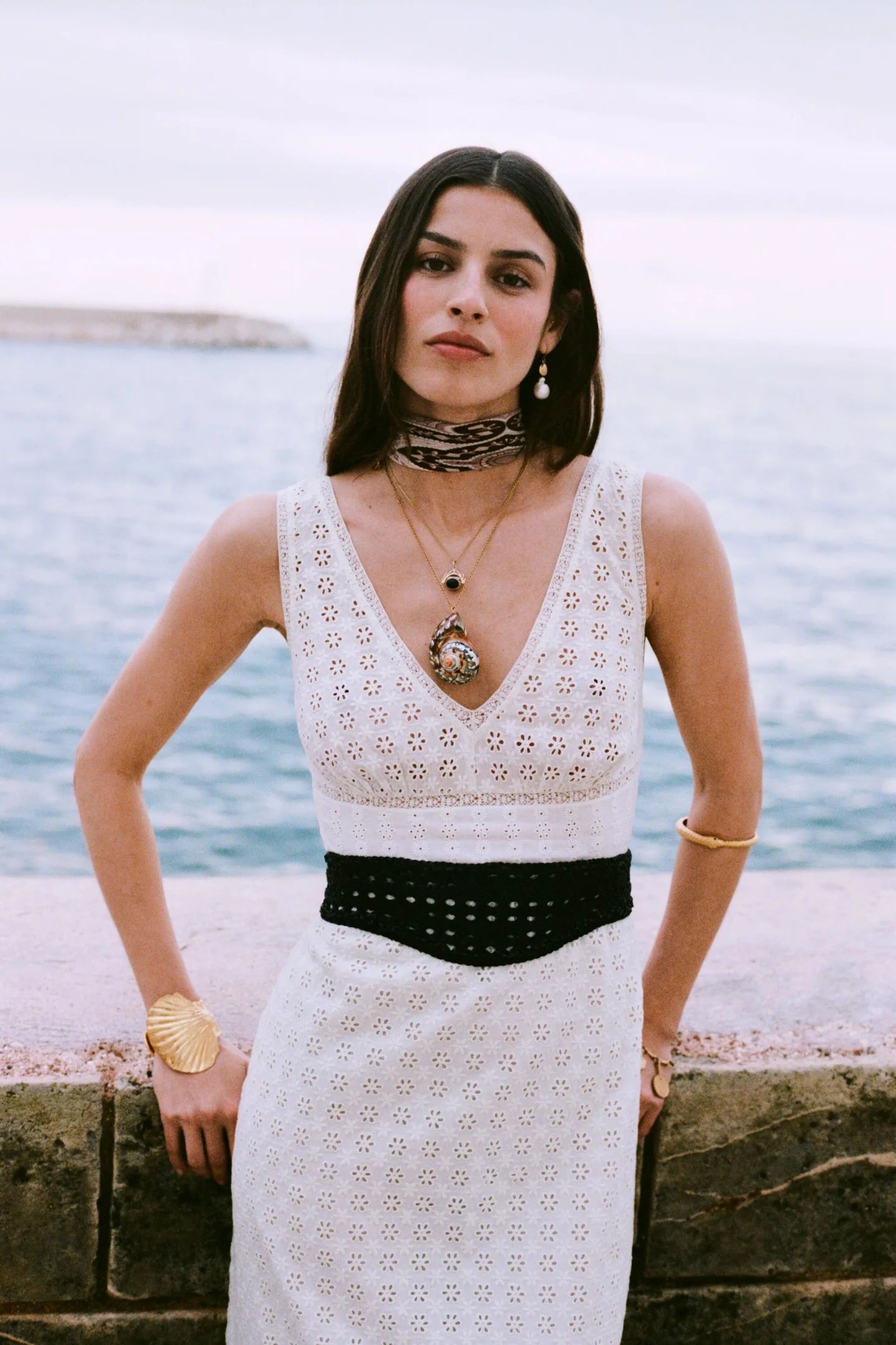 model wearing white dress and black woven belt