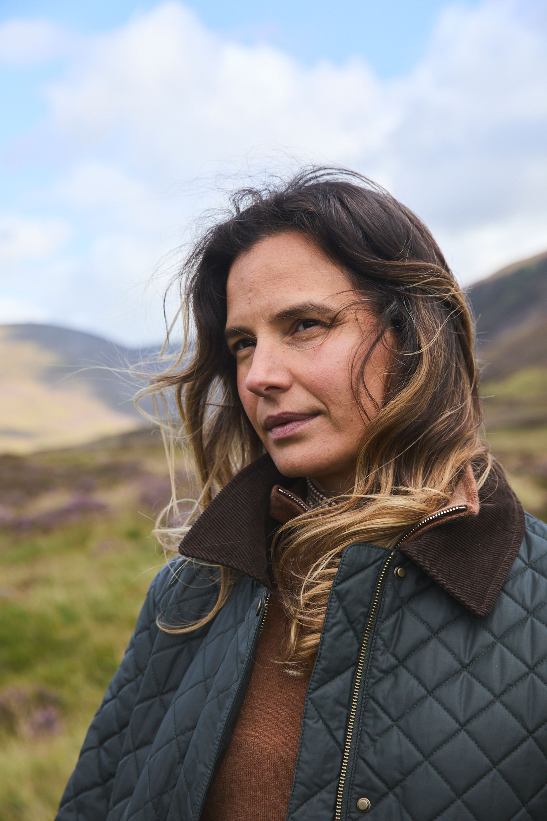 close up of female model on hills wearing quilted jacket