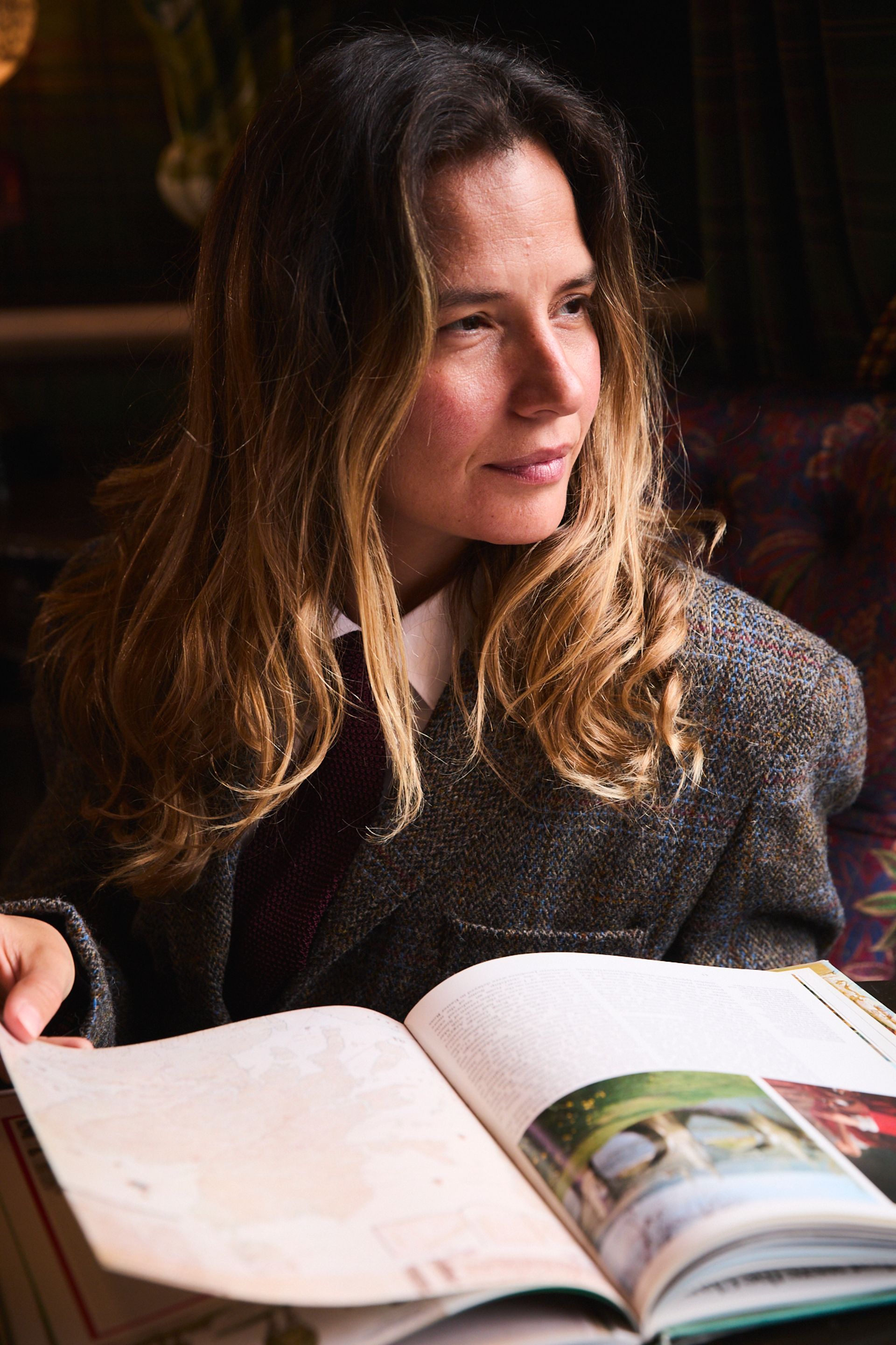 female model wearing harris weed blazer reading book