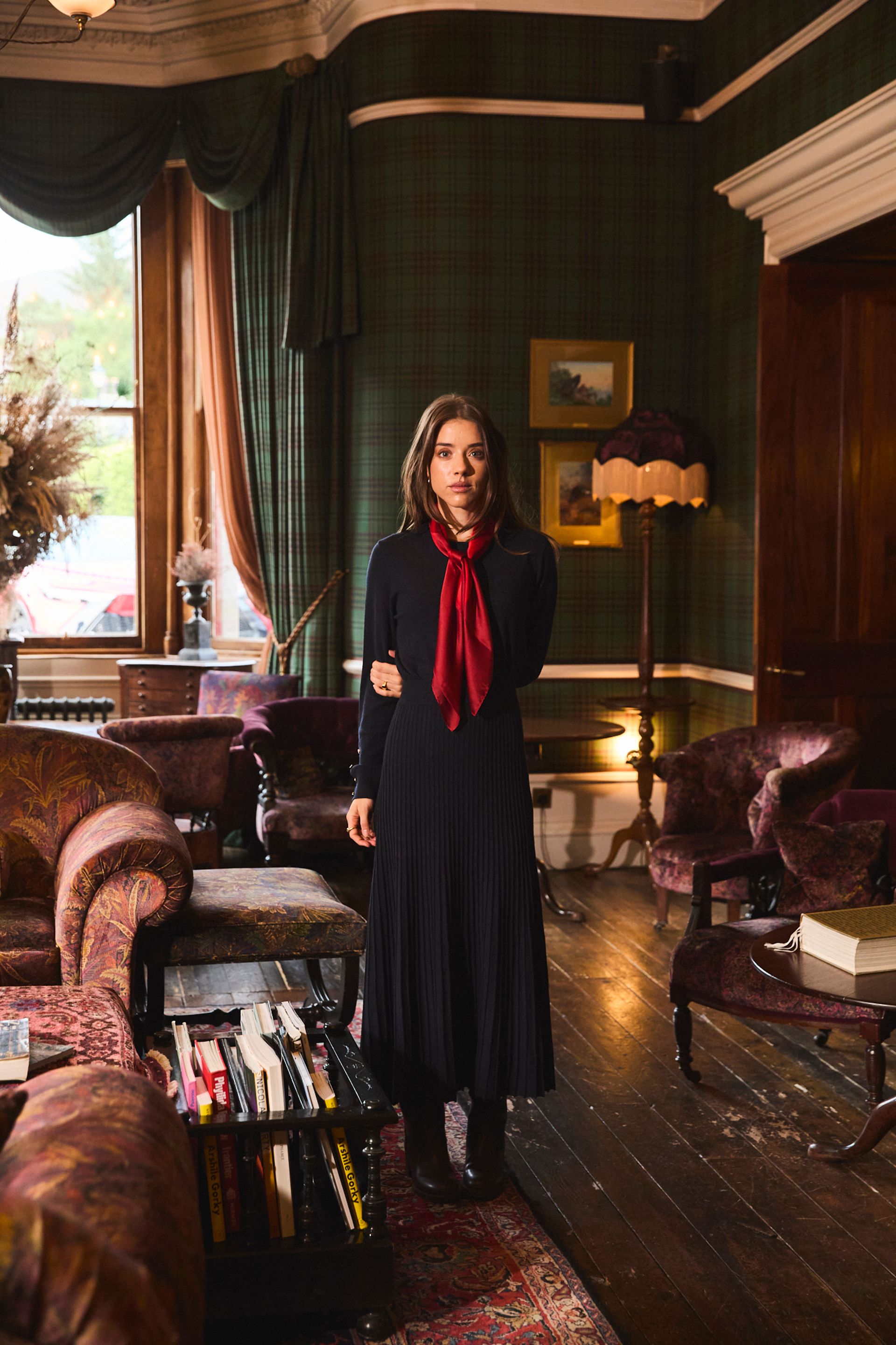 female model wearing black dress and red neck scarf