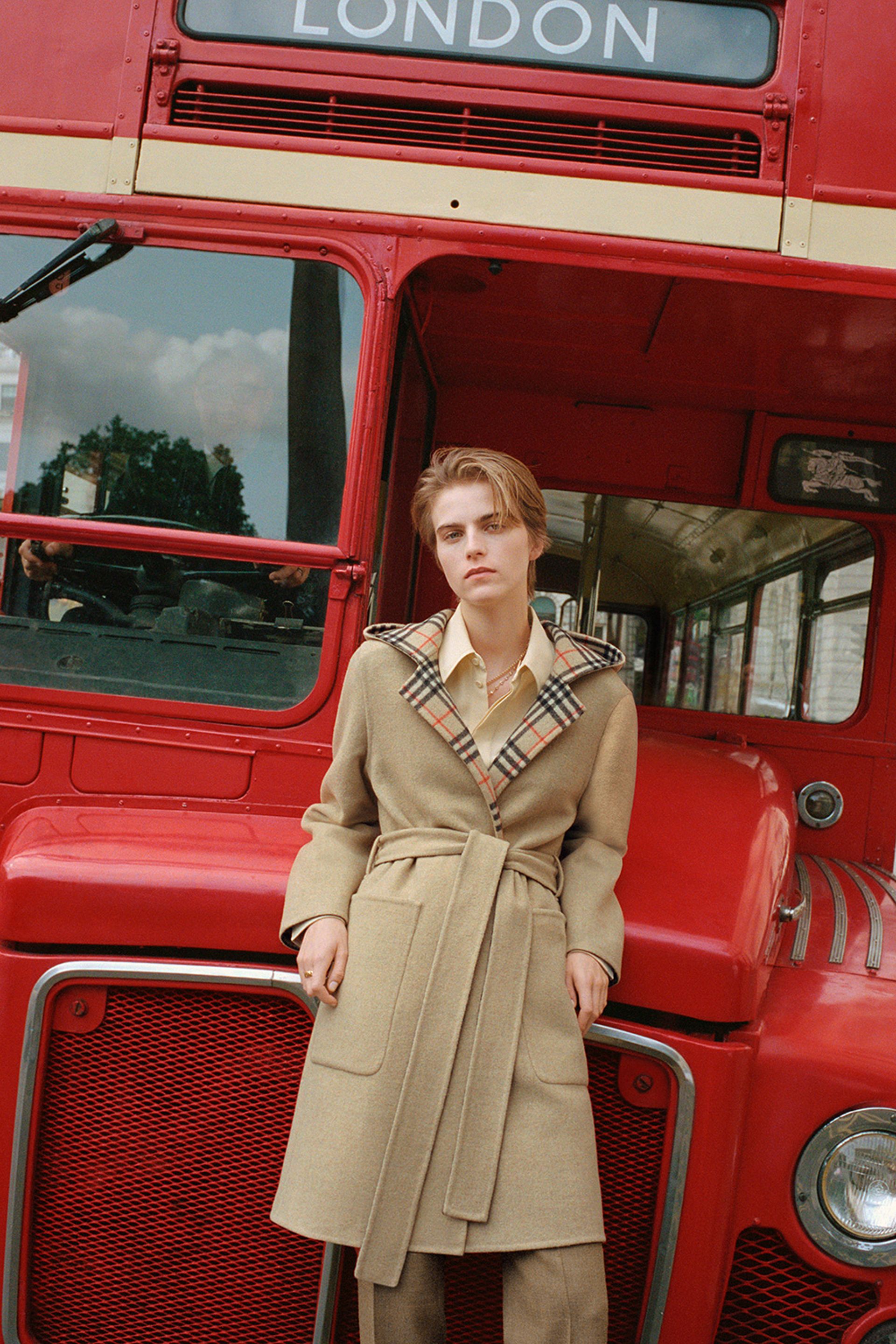 model standing by red London bus wearing wool cape Burberry coat 