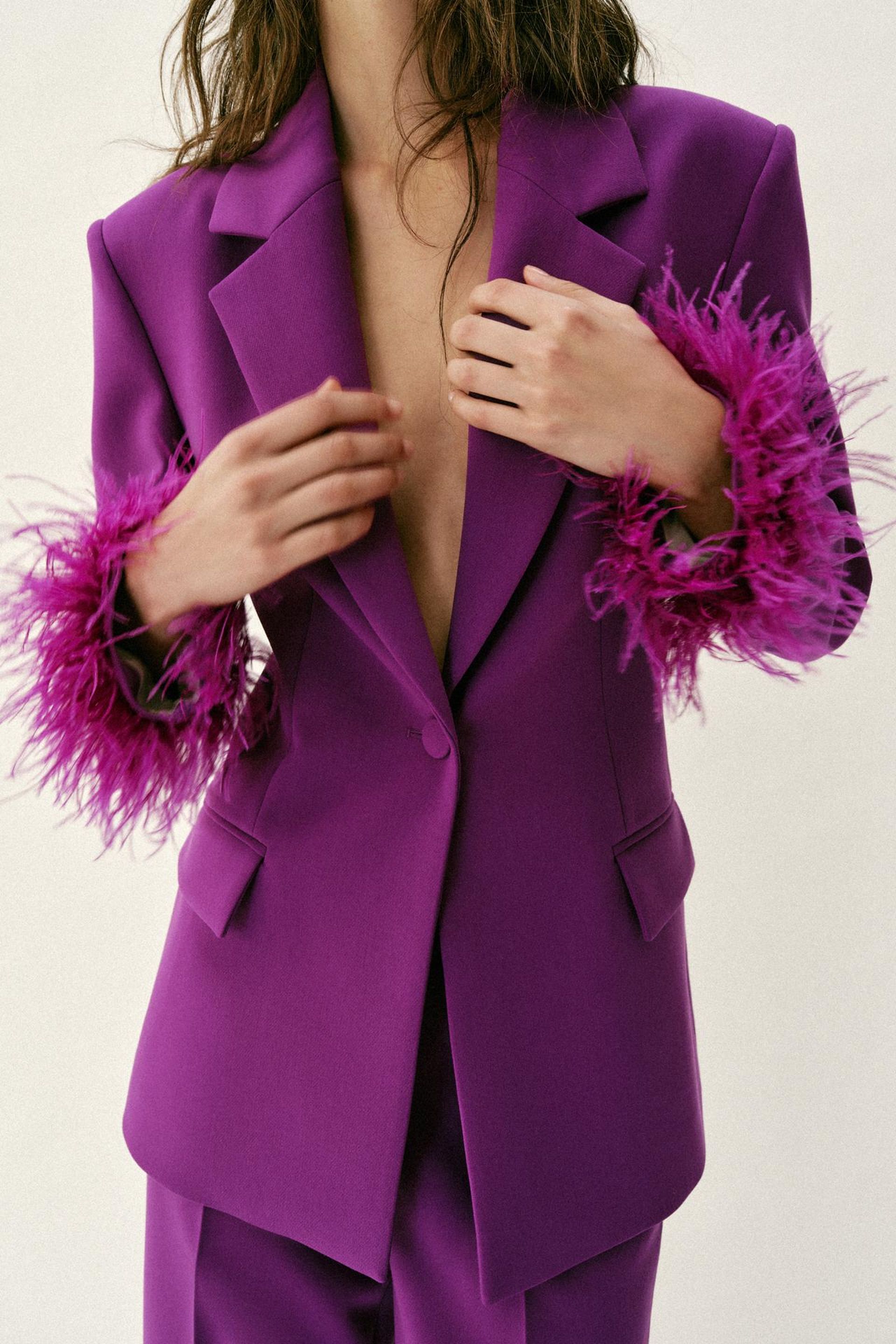 close up if model wearing purple blazer with feather trim cuffs