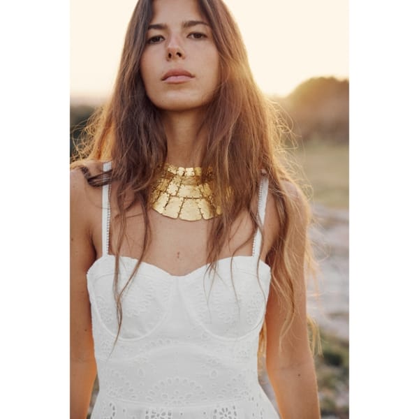 Zara metal plate necklace worn by woman in white dress - Grecian style