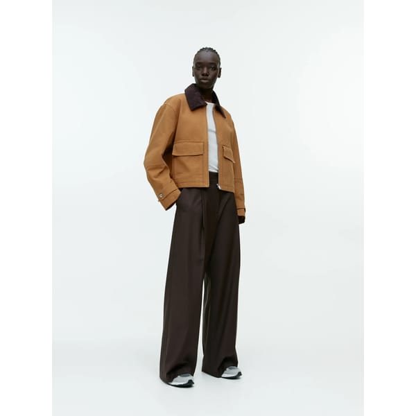 model wears brown trousers and jacket