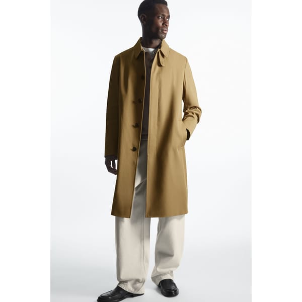 model wears beige car coat and white jeans
