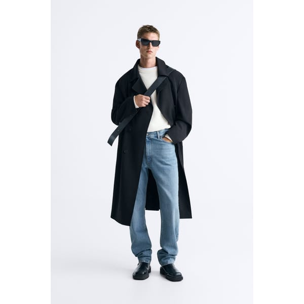 model wears black FLOWING TRENCH COAT and jeans