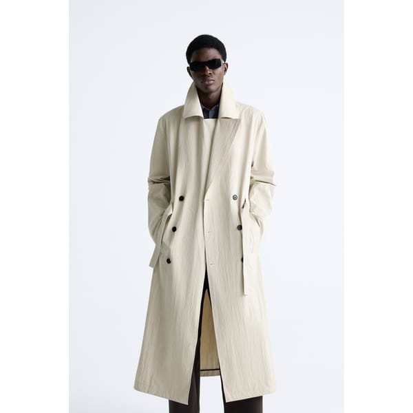 model wears OVERSIZED TECHNICAL TRENCH COAT in cream