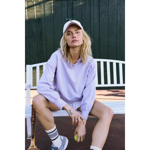 model on bench wears purple sweater