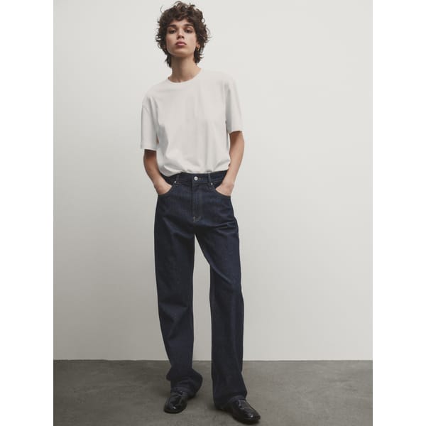 model wears black jeans and white tshirt