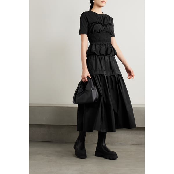 model wears black top and skirt