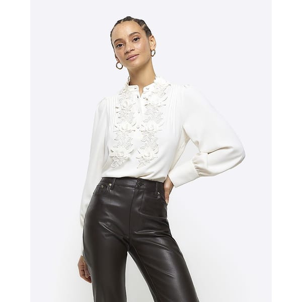model wearing white blouse and black leather trousers