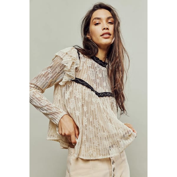 model wears white lace top with black trim
