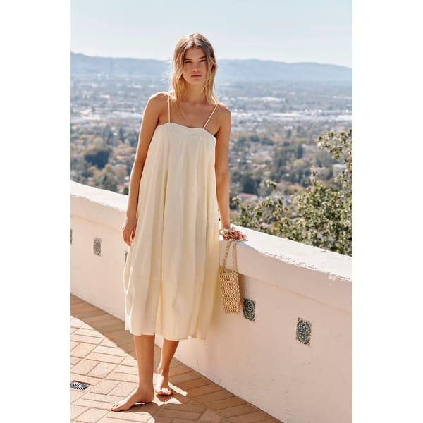 model on balcony wearing pale yellow sundress