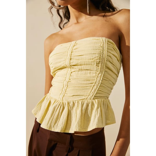 model wears yellow bandeau top