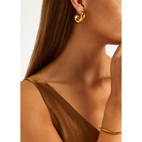 close up of model wearing AGMES Medium Celia gold vermeil hoop earrings