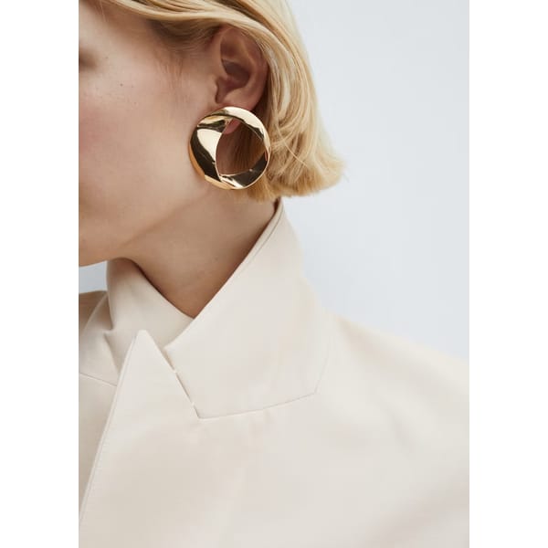 close up of model wearing Twisted hoop earrings in gold