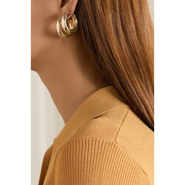 close up of model wearing nap JENNIFER FISHER Kevin Huggies gold-plated hoop earrings