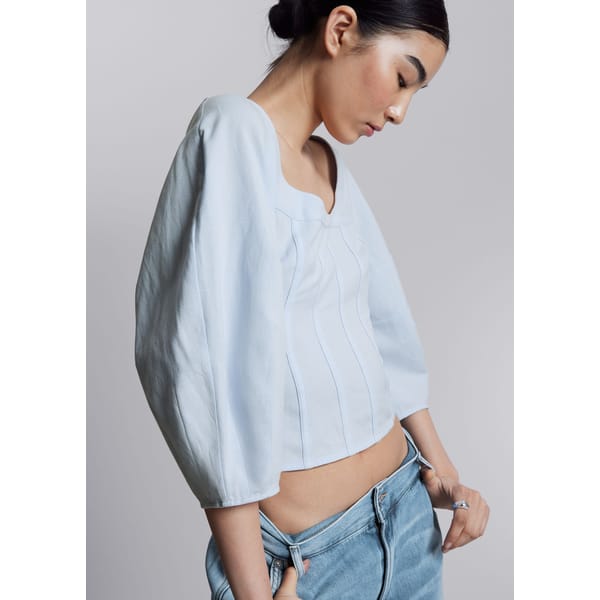 model wears pale blue cropped corset top