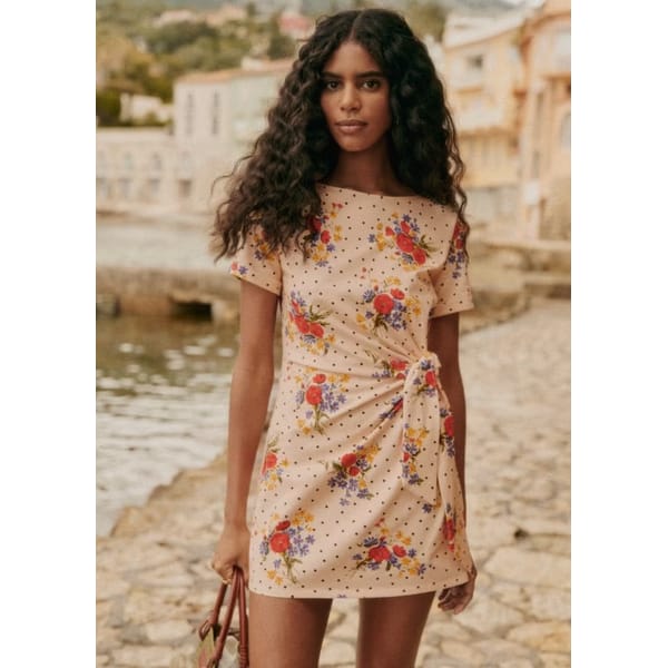 model on dock in short floral dress