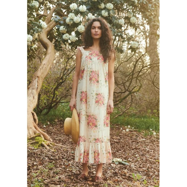 model in woods wearing white and pink floral print dress