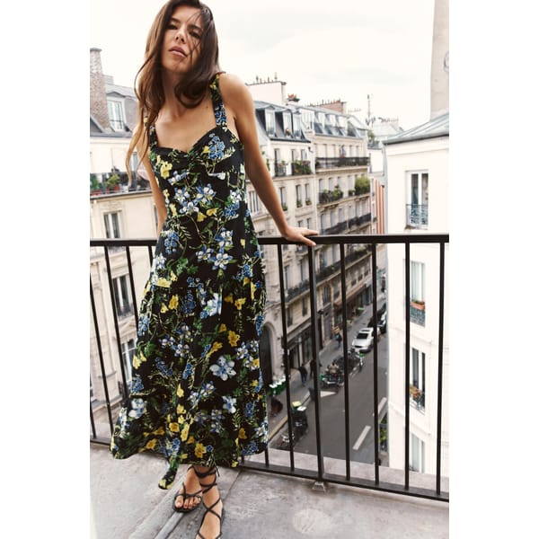 model on balcony wearing floral midi dress
