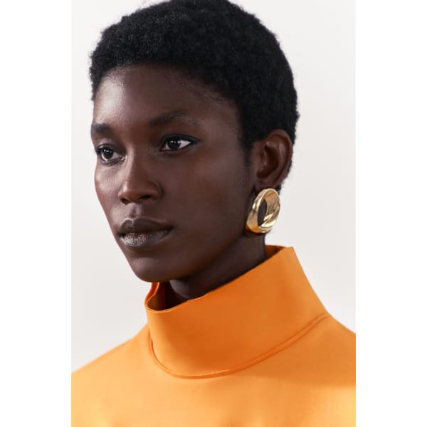 model wears big gold earrings