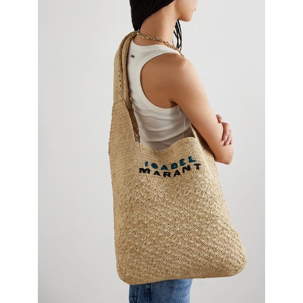 model from side wearing ISABEL Marant Praia Medium Embroidered Woven Raffia Tote