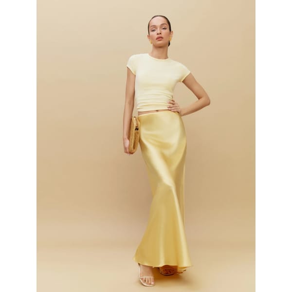 model wears yellow REFORMATION Bella Silk Skirt