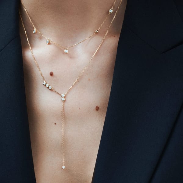 close up of model's chest wearing gold and diamond ivy necklace