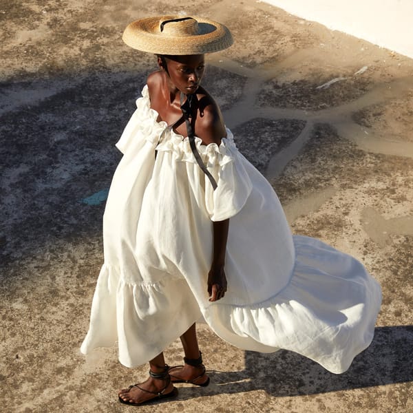 model wearing white voluminous dress with sunhat