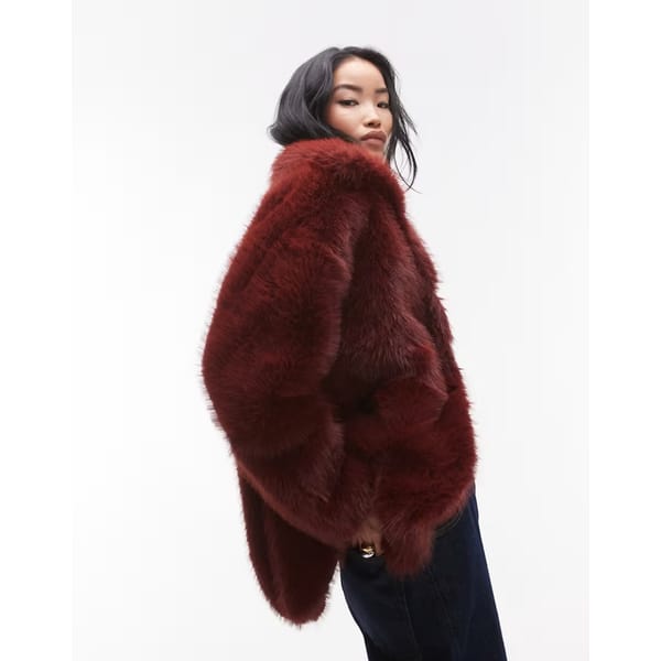 model wears Topshop faux fur funnel midi coat in burgundy