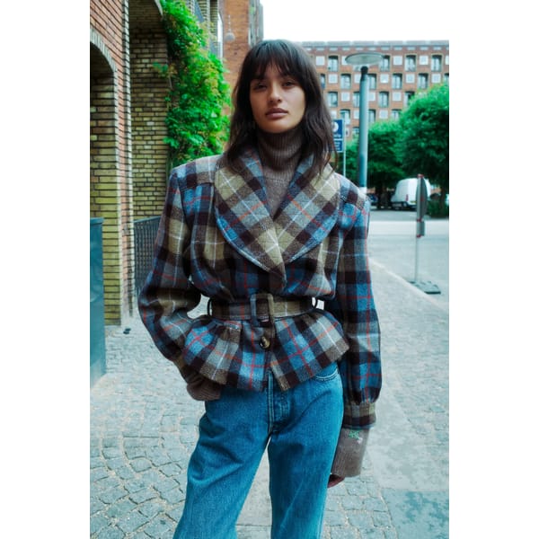 model in street wearing tartan blazer