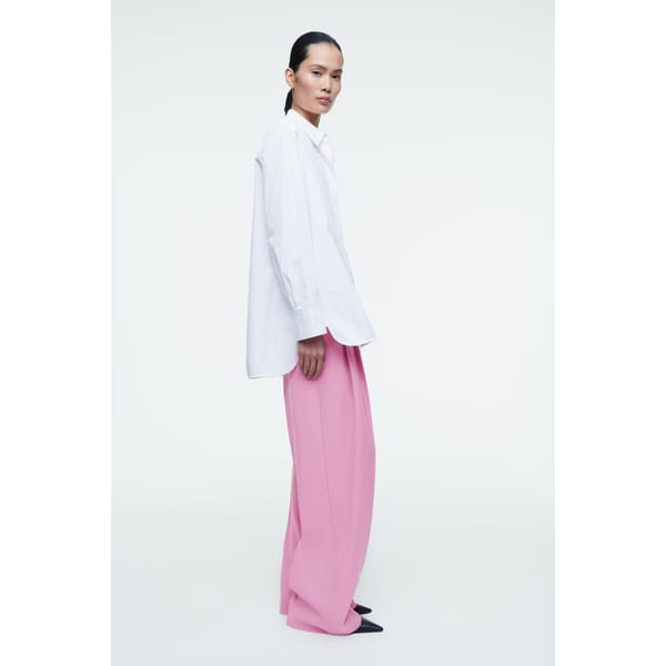 model wearing white shirt and pink trousers