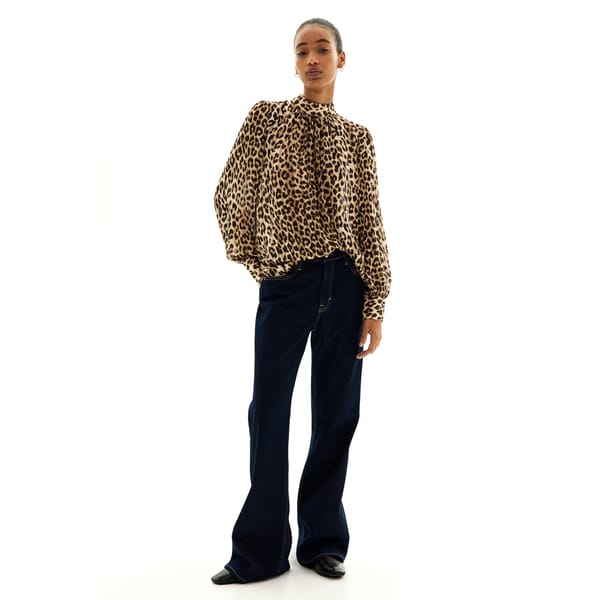 model wearing black trouser and leopard blouse