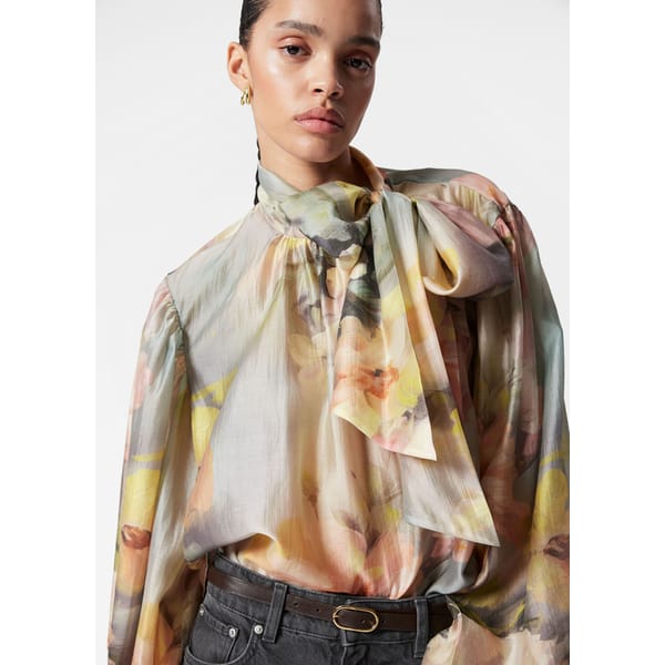 model wearing floral high neck blouse