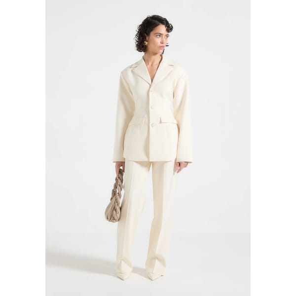 model wears MANIERE DE VOIR Wide Shoulder Cinch Waist Blazer - Cream