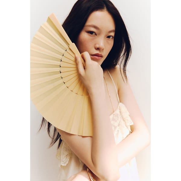 model holding light yellow fan